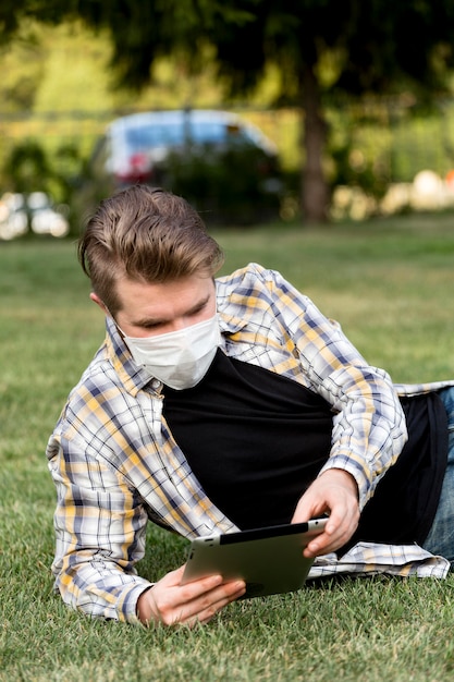 Foto gratuita hombre guapo con tableta al aire libre