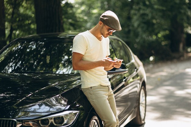 Hombre guapo con teléfono en coche