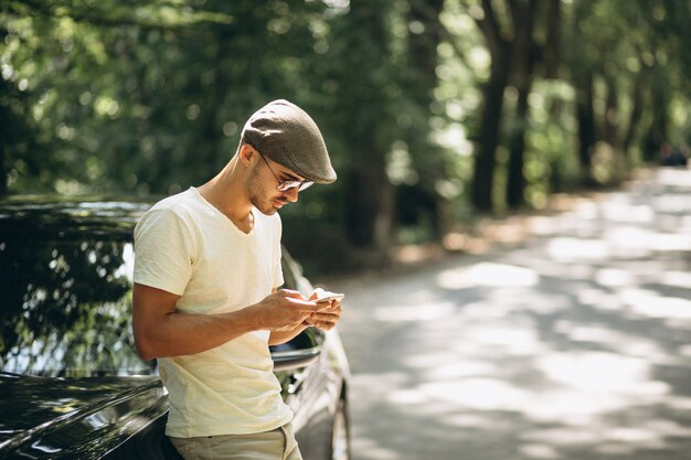 Hombre guapo con teléfono en coche