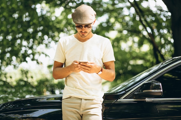 Hombre guapo con teléfono en coche