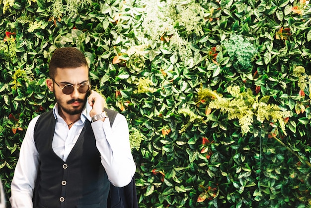 hombre guapo con teléfono inteligente para la conversación