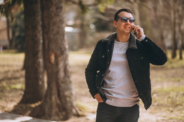 Hombre guapo con teléfono en el parque