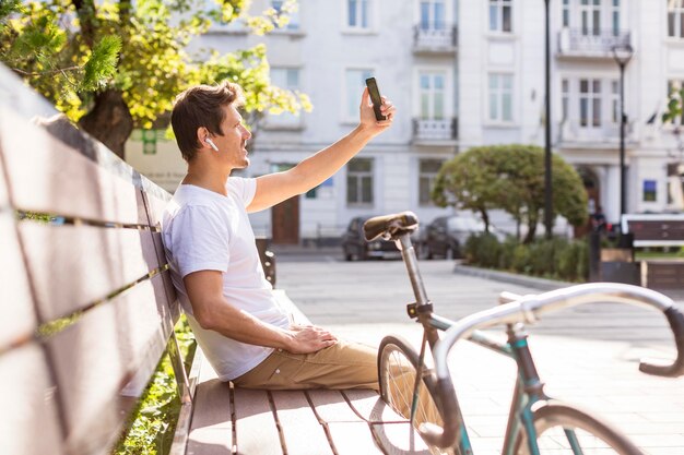 Hombre guapo tomando un selfie al aire libre