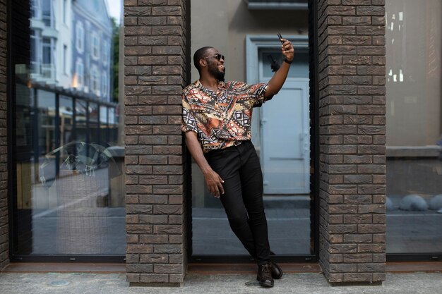 Hombre guapo tomando selfie con smartphone moderno al aire libre