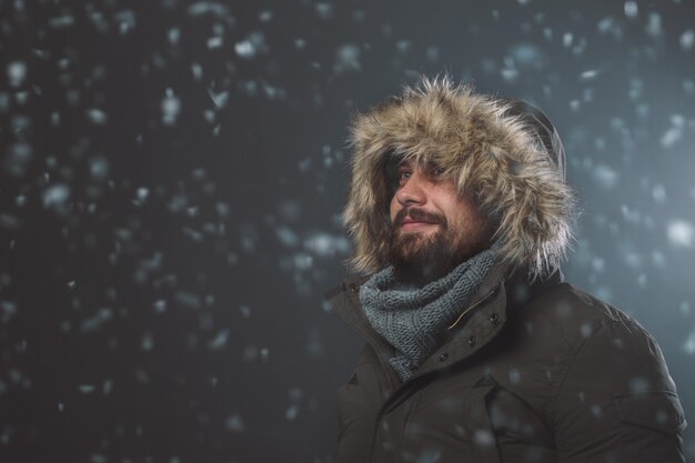 Hombre guapo en tormenta de nieve