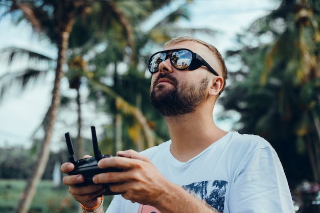 Hombre guapo usa drone en la calle.