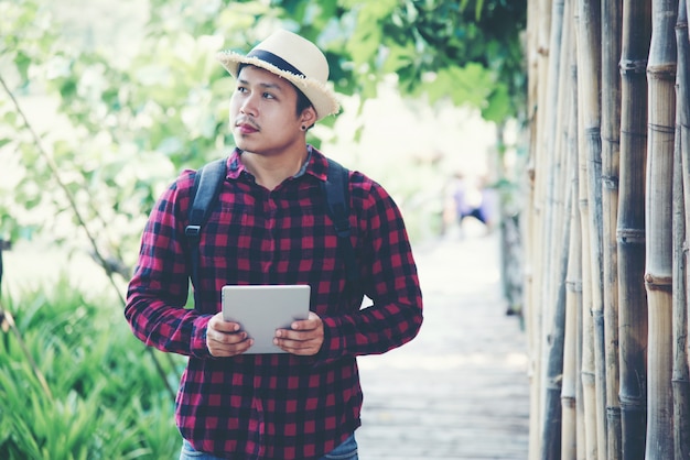 Hombre guapo usando laptop en la naturaleza de viaje