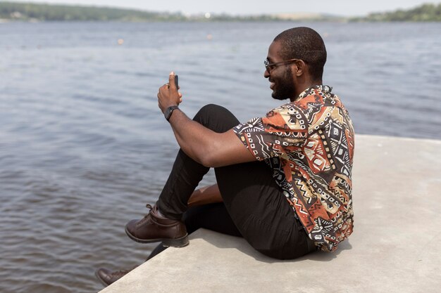 Hombre guapo con una videollamada con smartphone moderno al aire libre