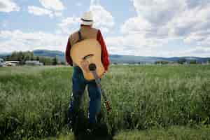 Foto gratuita hombre con guitarra preparándose para concierto de música country