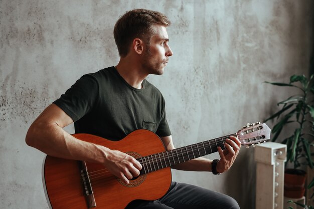 Hombre guitarrista tocando la guitarra en casa