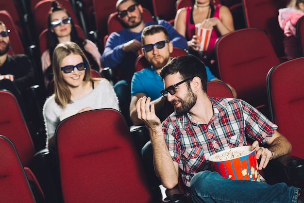 Hombre hablando con amigos en el cine