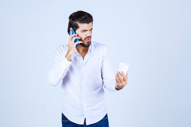 Hombre hablando con su nuevo modelo de teléfono inteligente azul