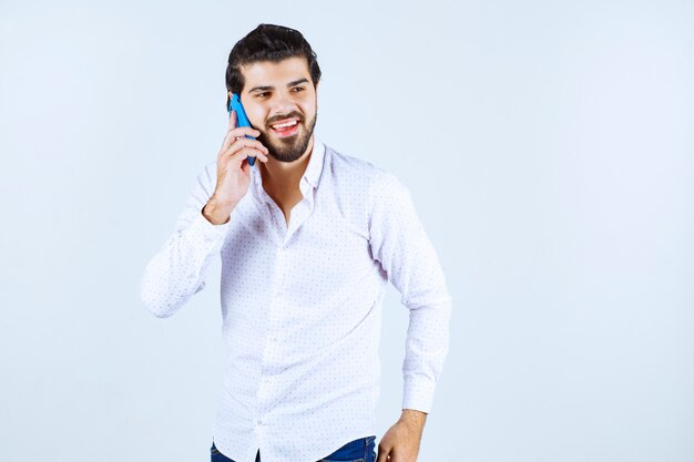 Hombre hablando con su nuevo modelo de teléfono inteligente azul