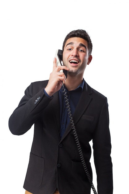 Hombre hablando por un teléfono blanco