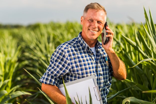 Hombre hablando por teléfono en un campo