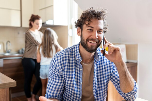 Foto gratuita hombre hablando por teléfono en la cocina