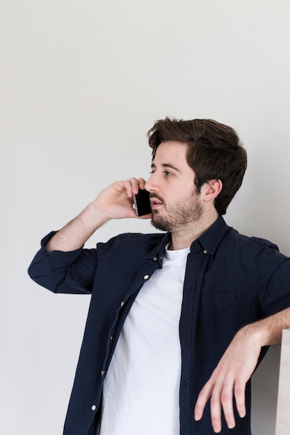 Foto gratuita hombre hablando en teléfono inteligente en la oficina