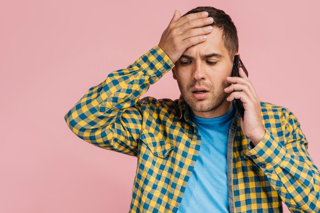 Hombre hablando por teléfono y recibiendo malas noticias