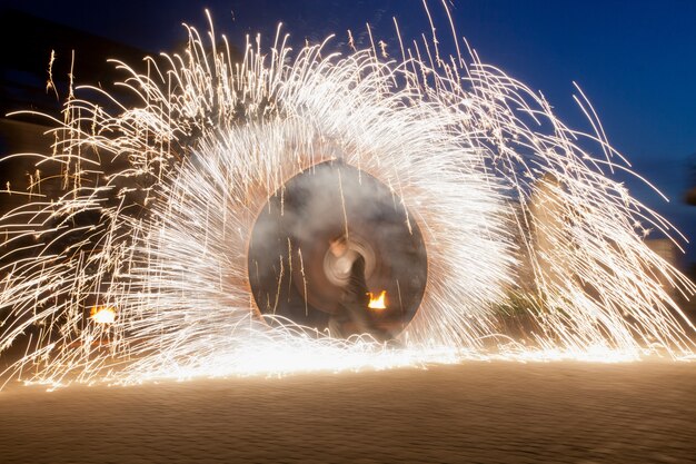 El hombre hace espectáculo con fuego chispeante