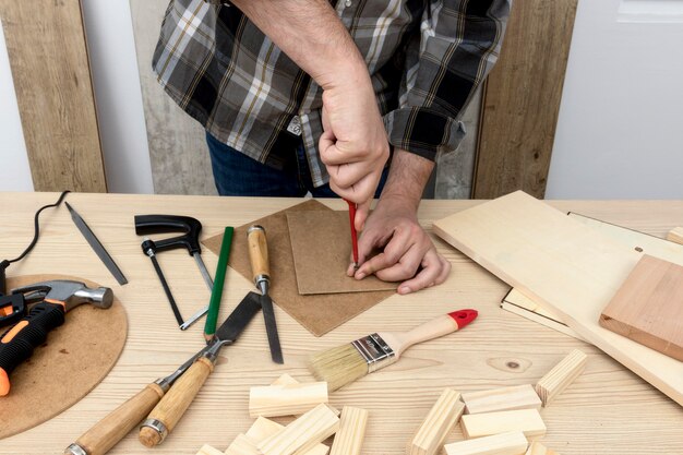 Hombre haciendo un agujero en el concepto de taller de carpintería de madera