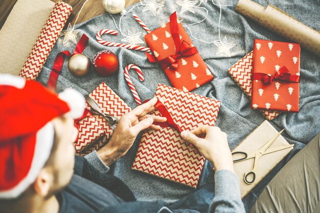 Hombre haciendo arco de cinta en regalo