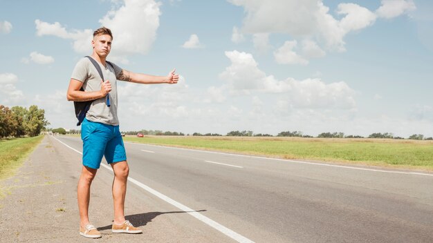 Hombre haciendo autostop en carretera