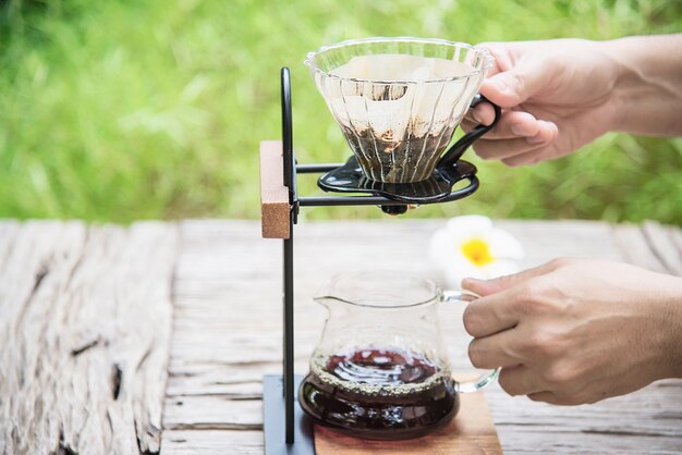 Hombre haciendo café fresco por goteo en cafetería vintage