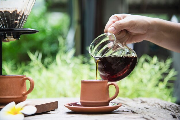 Hombre haciendo café fresco por goteo en cafetería vintage