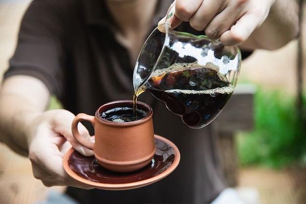 Hombre haciendo café fresco por goteo en cafetería vintage