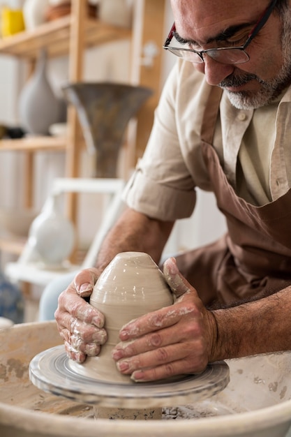 Foto gratuita hombre haciendo cerámica en interiores