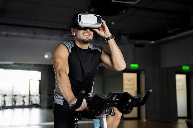 Foto gratuita hombre haciendo ciclismo indoor con gafas vr