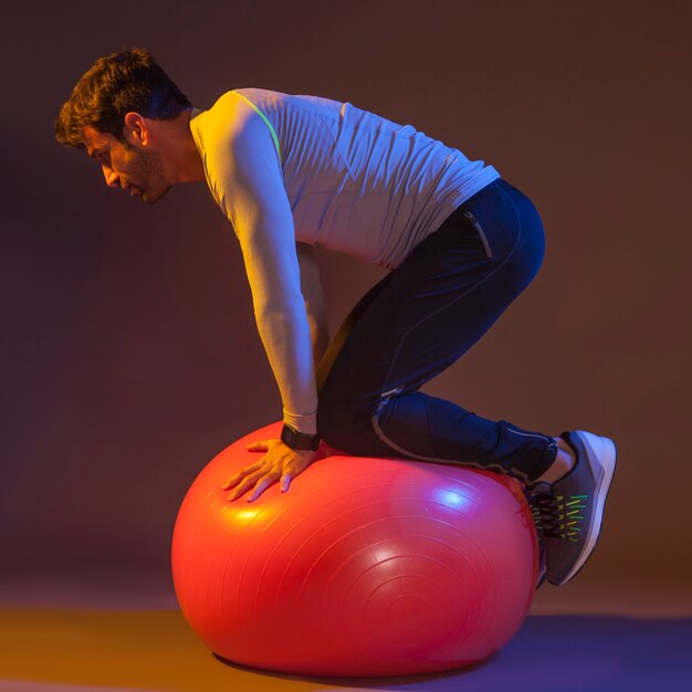 Hombre haciendo ejercicio de equilibrio en la bola de la aptitud