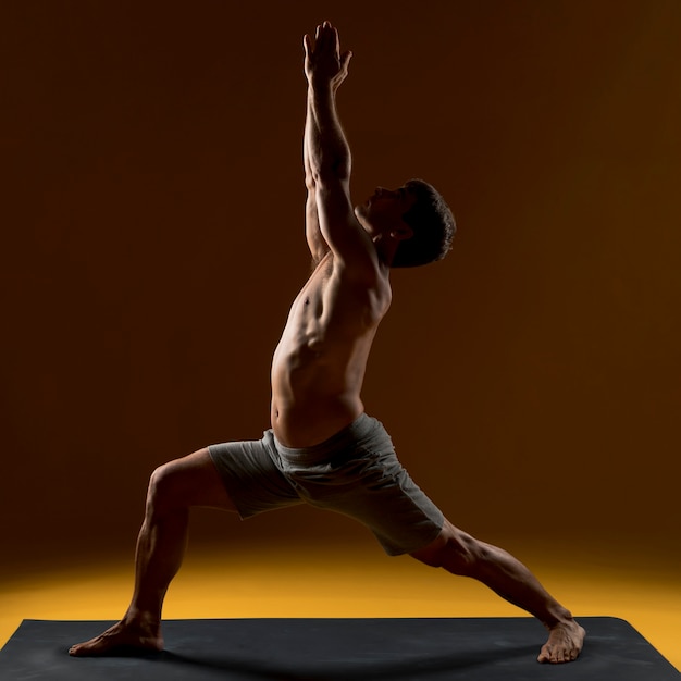 Hombre haciendo ejercicio en estera de yoga