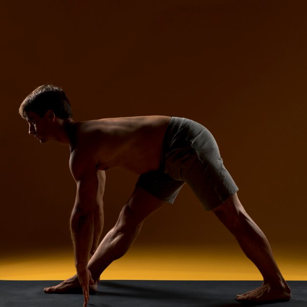 Hombre haciendo ejercicio en la estera de yoga