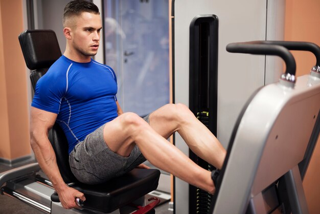 Hombre haciendo ejercicio en la máquina de prensa de piernas