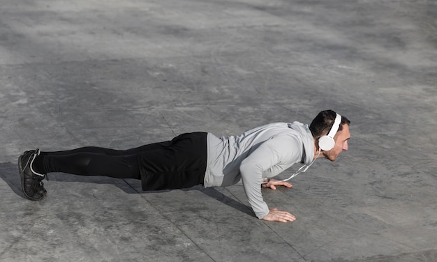 Foto gratuita hombre haciendo flexiones y escuchando música