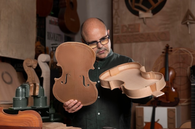 Foto gratuita hombre haciendo instrumentos en su taller solo