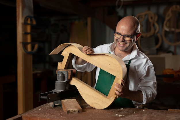 Foto gratuita hombre haciendo instrumentos en su taller