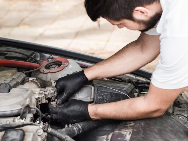 Foto gratuita hombre haciendo mantenimiento en motor