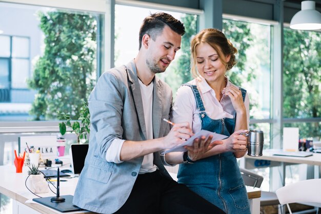 Hombre haciendo notas en papel para mujer