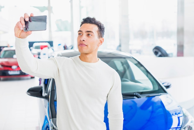 Hombre haciendo selfie en concesionario de coches