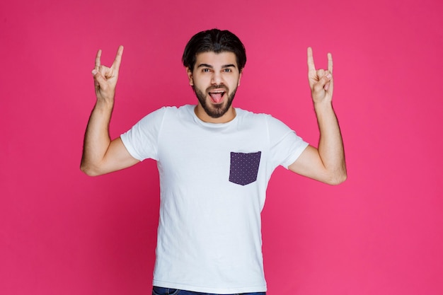 Hombre haciendo signo de lobo con las manos.