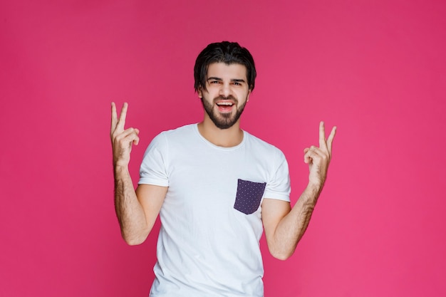 Hombre haciendo el signo de la mano de la paz y la amistad.