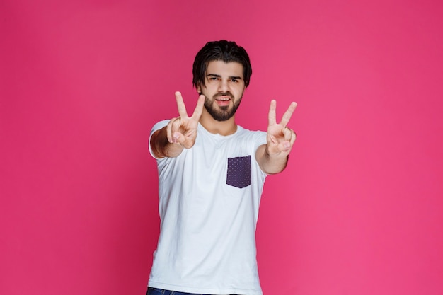 Hombre haciendo el signo de la mano de la paz y la amistad.