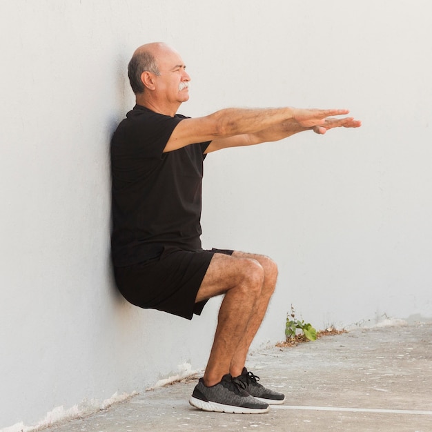 Hombre haciendo soporte de pared ejercicio físico