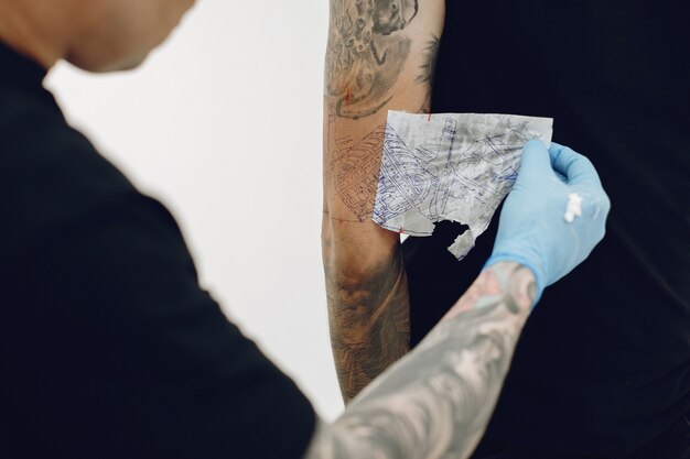 Hombre haciendo un tatuaje en un salón de tatuajes