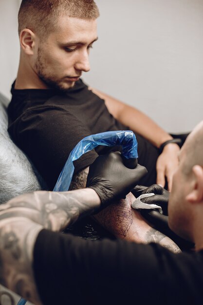 Hombre haciendo un tatuaje en un salón de tatuajes