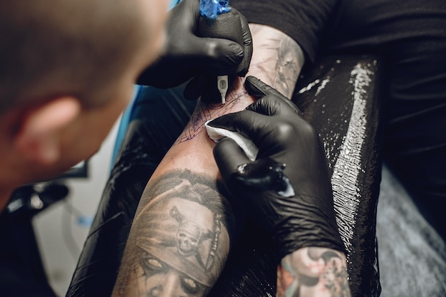 Hombre haciendo un tatuaje en un salón de tatuajes