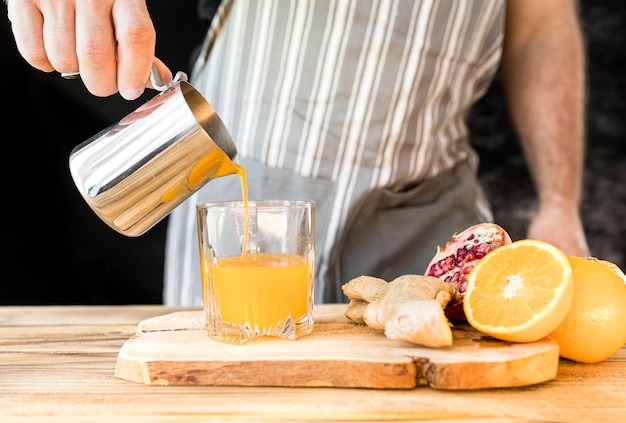 Hombre haciendo una vista frontal de jugo de naranja