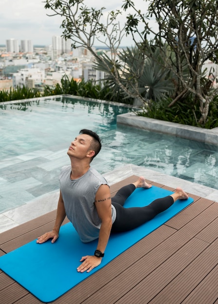 Hombre haciendo yoga en la piscina